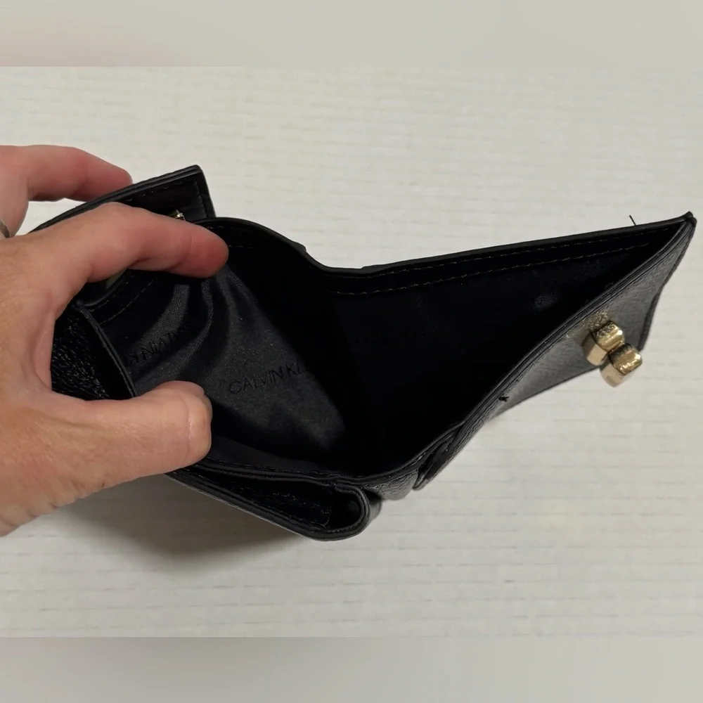 Calvin Klein black trifold wallet with a gold-tone metal closure